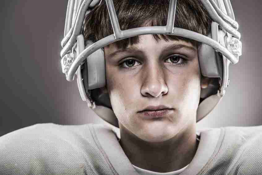 youth football player wearing helmet, close-up