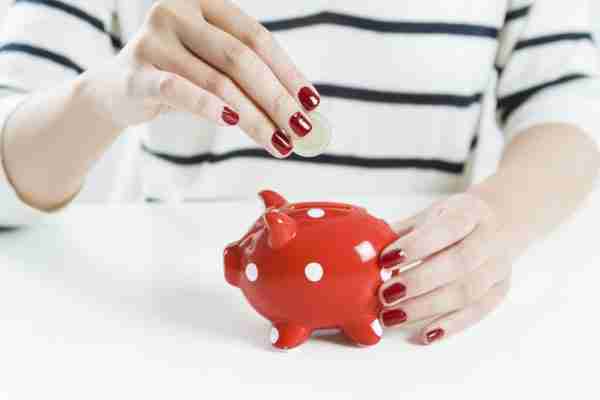 woman saving money with red piggy bank