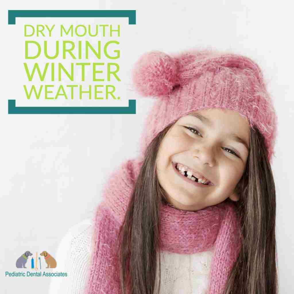 little girl in pink winter hat, scarf and white sweather smiling